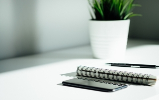 pen, notebook, and smartphone on table