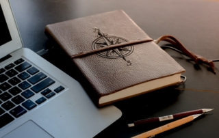 brown book beside MacBook