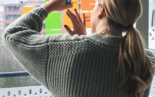 woman in gray sweater holding smartphone